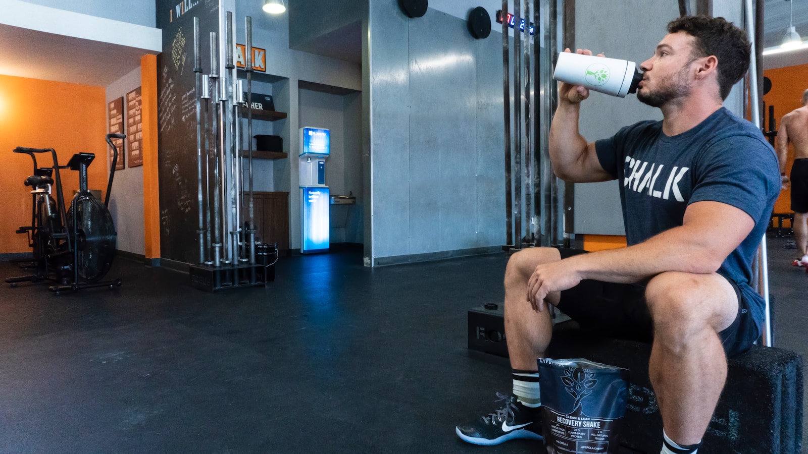 a bulk American gym goer and fitness enthusiast drinking from one of the best protein shakers